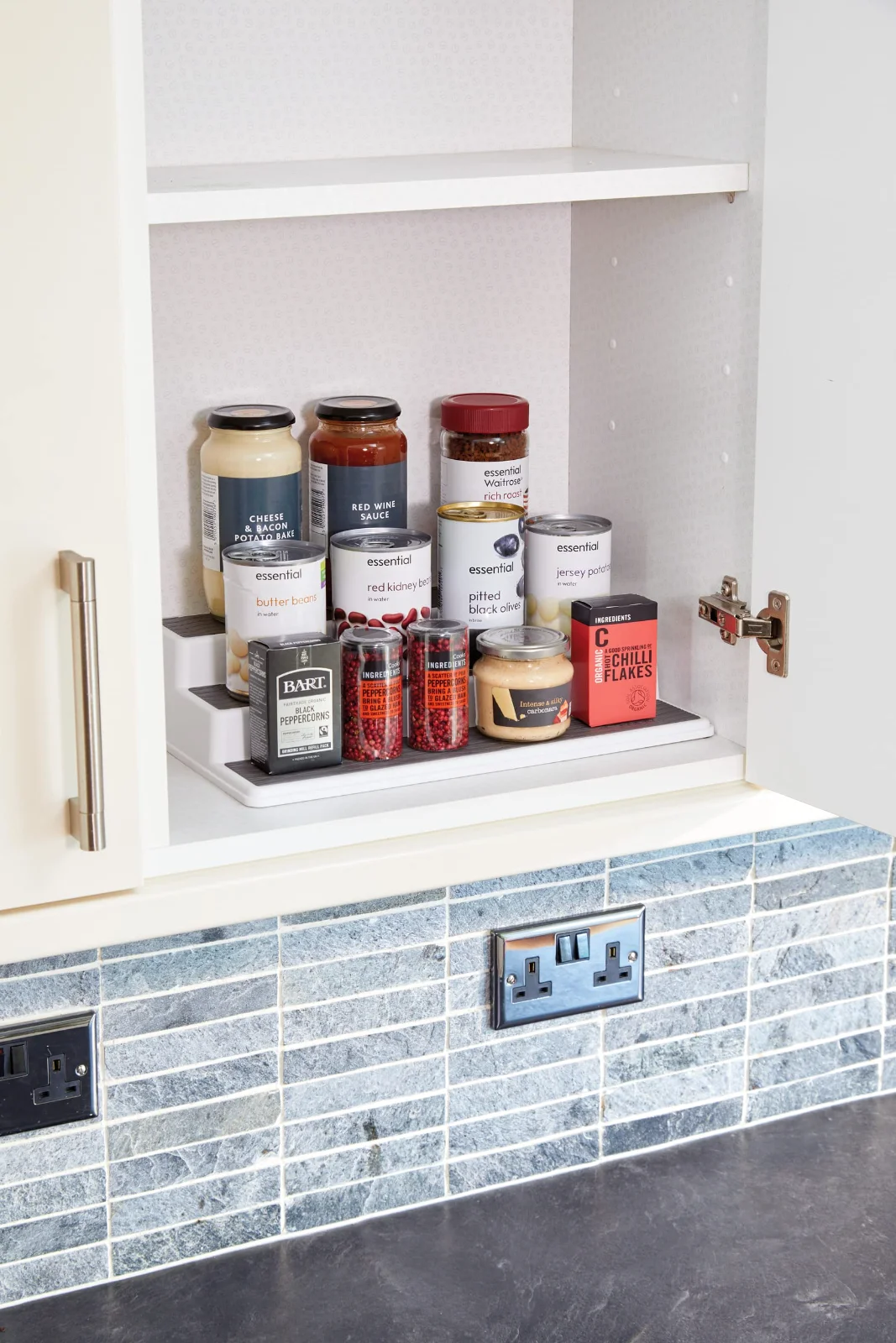 Three tiers in a cupboard: every label on every row facing out.